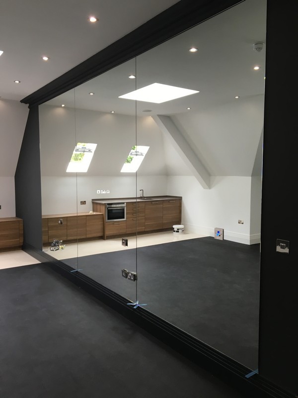 Frameless glass partition in loft conversion by Luton glaziers